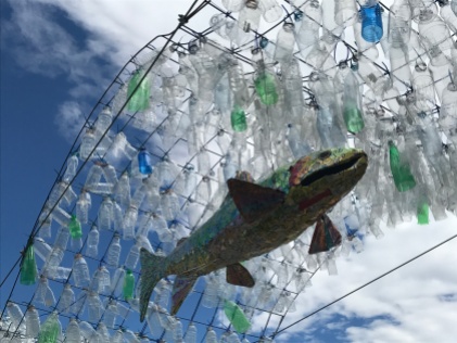 Fish in a river, the water made out of plastic bottles